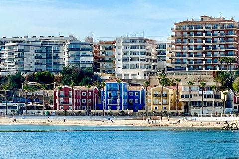 Bunte Häuser am Strand, dahinter Ferienappartments: Villajoyosa an der spanischen Costa Blanca