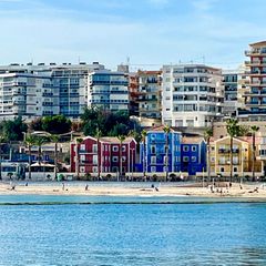 Bunte Häuser am Strand, dahinter Ferienappartments: Villajoyosa an der spanischen Costa Blanca