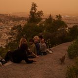 Touristen spielen mit einer Katze auf dem Lycabettus-Hügel, während im Hintergrund eine unheimliche Atmosphäre in Athen herrscht. Die Region Attika rund um Athen sei aufgrund klimatischer Bedingungen regelmäßig vor allem im Frühjahr und Herbst von dem Phänomen betroffen, sagten Meteorologen der Tageszeitung "Kathimerini".