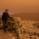 Dieser Mann versucht, sich mit einer Maske vor  dem Staub zu schützen. Zu recht: Der Griechische Pneumologen-Verband teilte mit, der afrikanische Staub enthalte selbst kleinste Partikel, die tief in die Lunge eindringen könnten. Insofern bietet eine OP-Maske wohl keinen perfekten Schutz, ist aber besser als nichts.