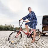 Limo sitzt auf seinen Fahrrad auf einem Parkpltz. Im Hintergrund steht sein Camper