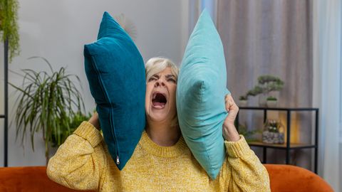 Wütende Frau schreit in ein Kissen
