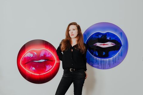 Esther Bockwyt, fotografiert in ihrer Wohnung in Recklinghausen, vor Bildern der britischen Künstlerin Sara Pope