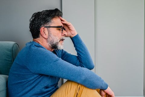 Ein frustrierter Mann sitzt auf dem Fußboden
