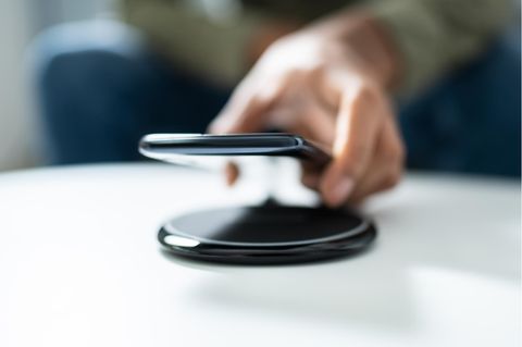 Induktives Laden von iPhones: Smartphone wird auf einem Qi-Ladegerät gelegt