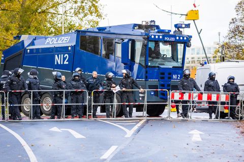 Polizisten stehen vor einem Wasserwerfer bei einem Bundesliga-Spiel