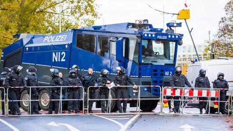 Polizisten stehen vor einem Wasserwerfer bei einem Bundesliga-Spiel