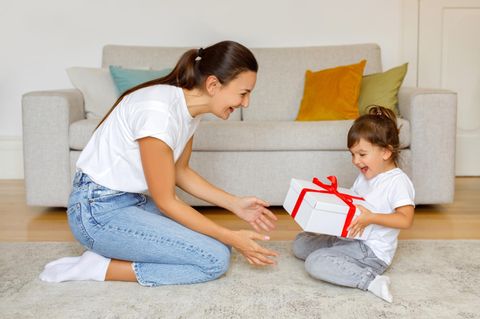 Eine Mutter überreicht ihrer Tochter ein Geschenk