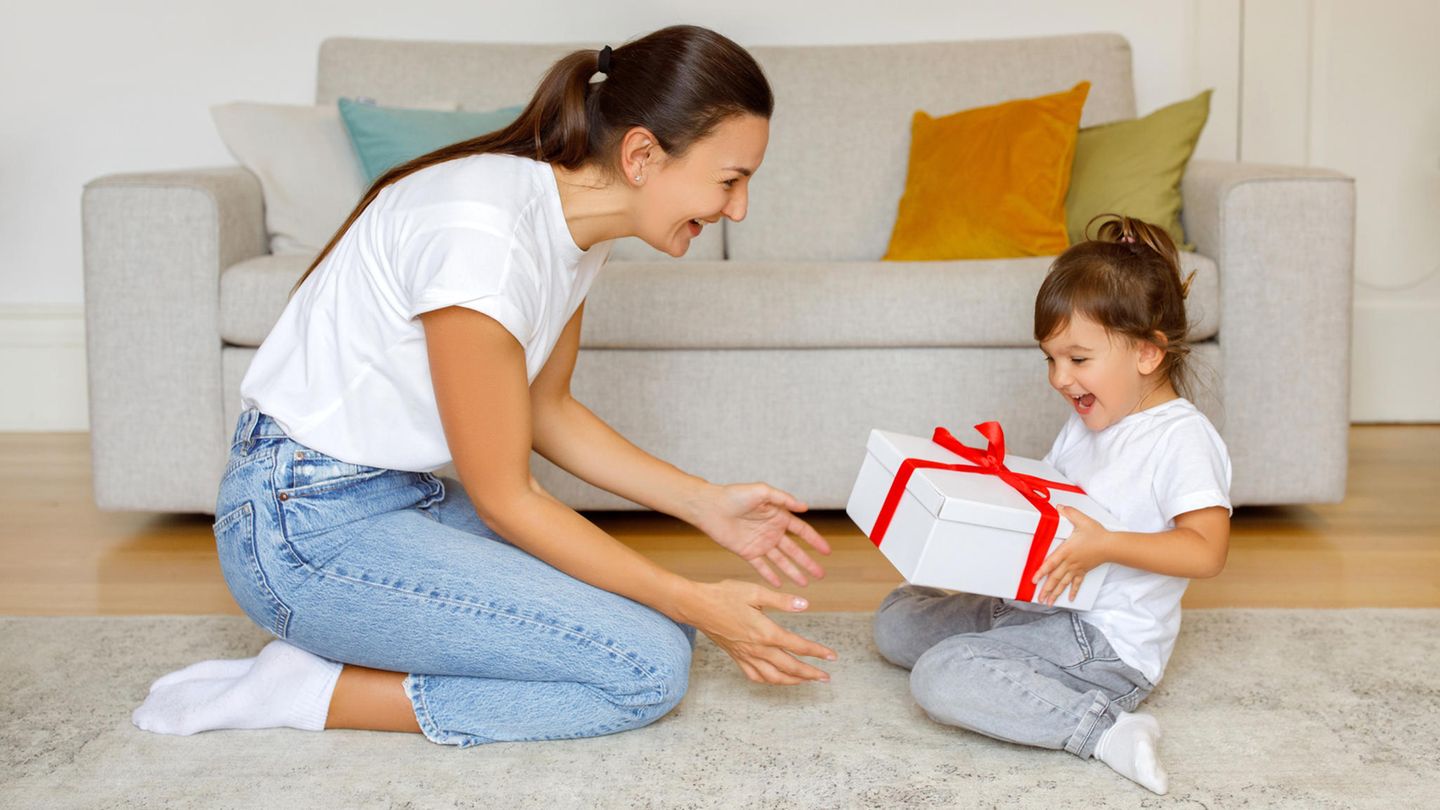 Eine Mutter überreicht ihrer Tochter ein Geschenk