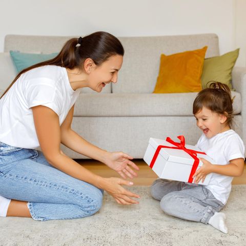 Eine Mutter überreicht ihrer Tochter ein Geschenk