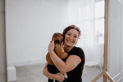 Paulina hält ihr Baby in den Armen und strahlt