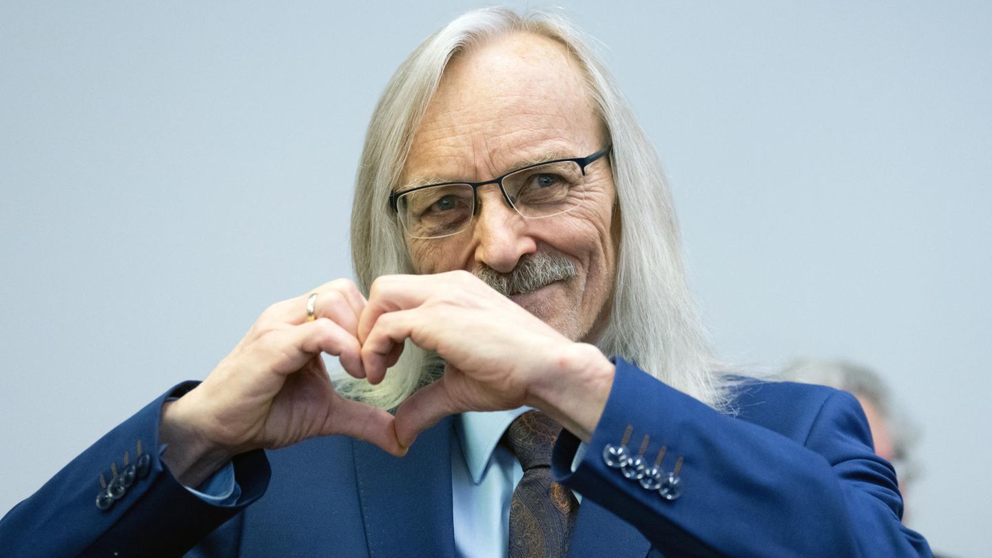 Maximilian Eder formt, ans Publikum gewandt, ein Herz mit seinen Händen. Seine Fans im Gerichtssaal applaudieren und jubeln