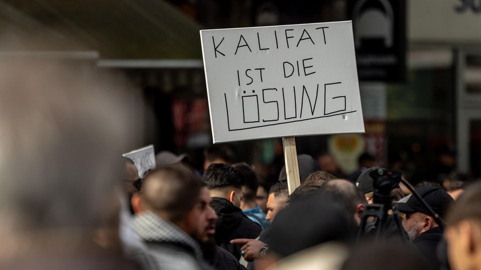 Teilnehmer einer islamistischen Demonstration halten ein Plakat mit der Aufschrift in der Hand 