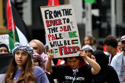Eine Frau hält ein Plakat während eines Pro-Palästina-Protestes in die Höhe