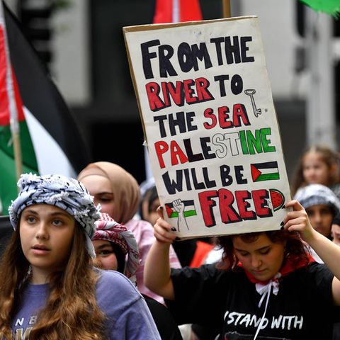 Eine Frau hält ein Plakat während eines Pro-Palästina-Protestes in die Höhe