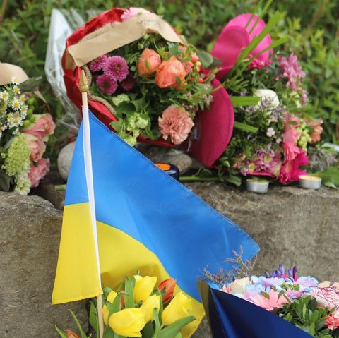 Am Tatort im bayerischen Murnau haben Ukrainer Blumensträuße und eine ukrainische Flagge aufgestellt