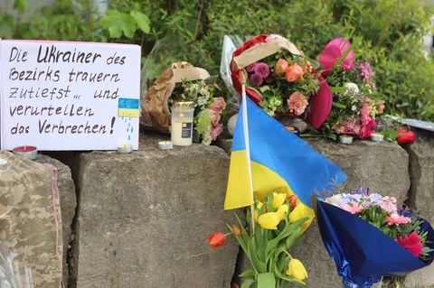 Am Tatort im bayerischen Murnau haben Ukrainer Blumensträuße und eine ukrainische Flagge aufgestellt