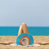 Frau mit Sonnenhut am Strand