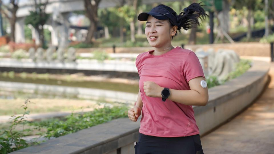 Ausdauersport: Joggerin trägt einen kleinen, weißen Glucose-Sensor am Arm