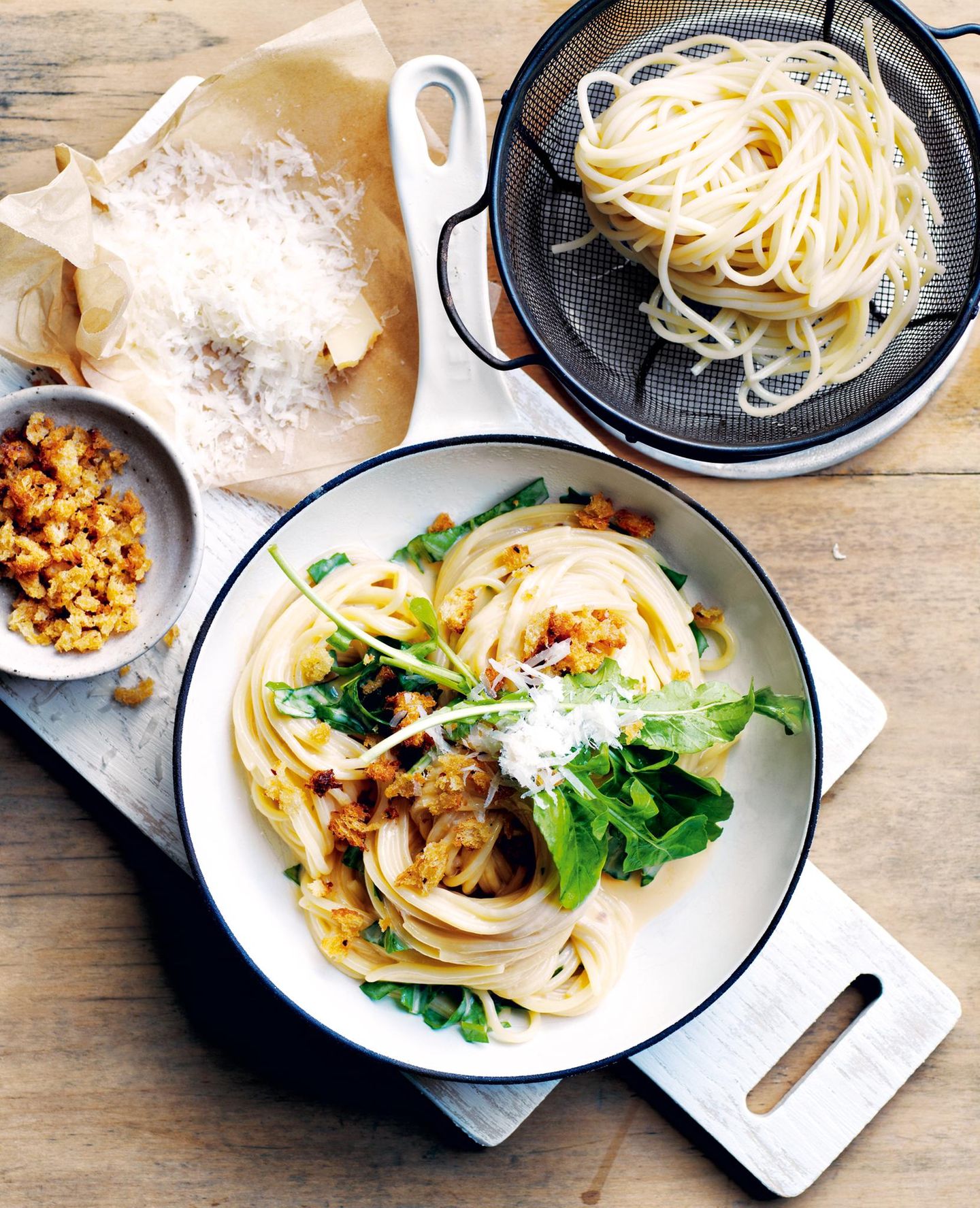 Parmesan-Pasta mit Knusperstreusel  400 g Spaghetti  250 ml Rahm (Sahne)  4 Eigelb, leicht verschlagen  80 g fein geriebener Parmesan, mehr zum Servieren Meersalz und schwarzer Pfeffer aus der Mühle  100 g Rucola, gehackt, mehr zum Servieren  2 TL fein geriebene Zitronenschale     Für die Knusperstreusel  140 g frische Sauerteigbrot-Krumen  2 EL Olivenöl extra vergine  2 TL getrocknete Chiliflocken     Für die Knusperstreusel den Backofen auf 180 °C vorheizen. Ein großes Backblech mit Backpapier auslegen.  Brotkrumen, Öl und Chiliflocken mischen. Auf das vorbereitete Blech geben und in 5–8 Minuten goldbraun backen. Dabei gelegentlich umrühren. Beiseite stellen.  Die Pasta in einem großen Topf mit kochendem Salzwasser bissfest garen. Abgießen und beiseite stellen.  Rahm, Eigelb und Parmesan in einer Schüssel verschlagen.  Den Topf bei schwacher Hitze wieder aufsetzen. Die Parmesan- Rahm-Mischung hineingeben und 2 Minuten köcheln, dabei sanft mit einem Spatel rühren, bis die Masse dicker wird, aber nicht gerinnt. Mit Salz und Pfeffer bestreuen.  Die Pasta beigeben und 1–2 Minuten unter Rühren erhitzen, bis die Sauce verteilt ist. Rucola und Zitronenschale einrühren.  Die Pasta auf Schüsseln verteilen und mit den Streuseln, dem zusätzlichen Rucola und Parmesan bestreuen.