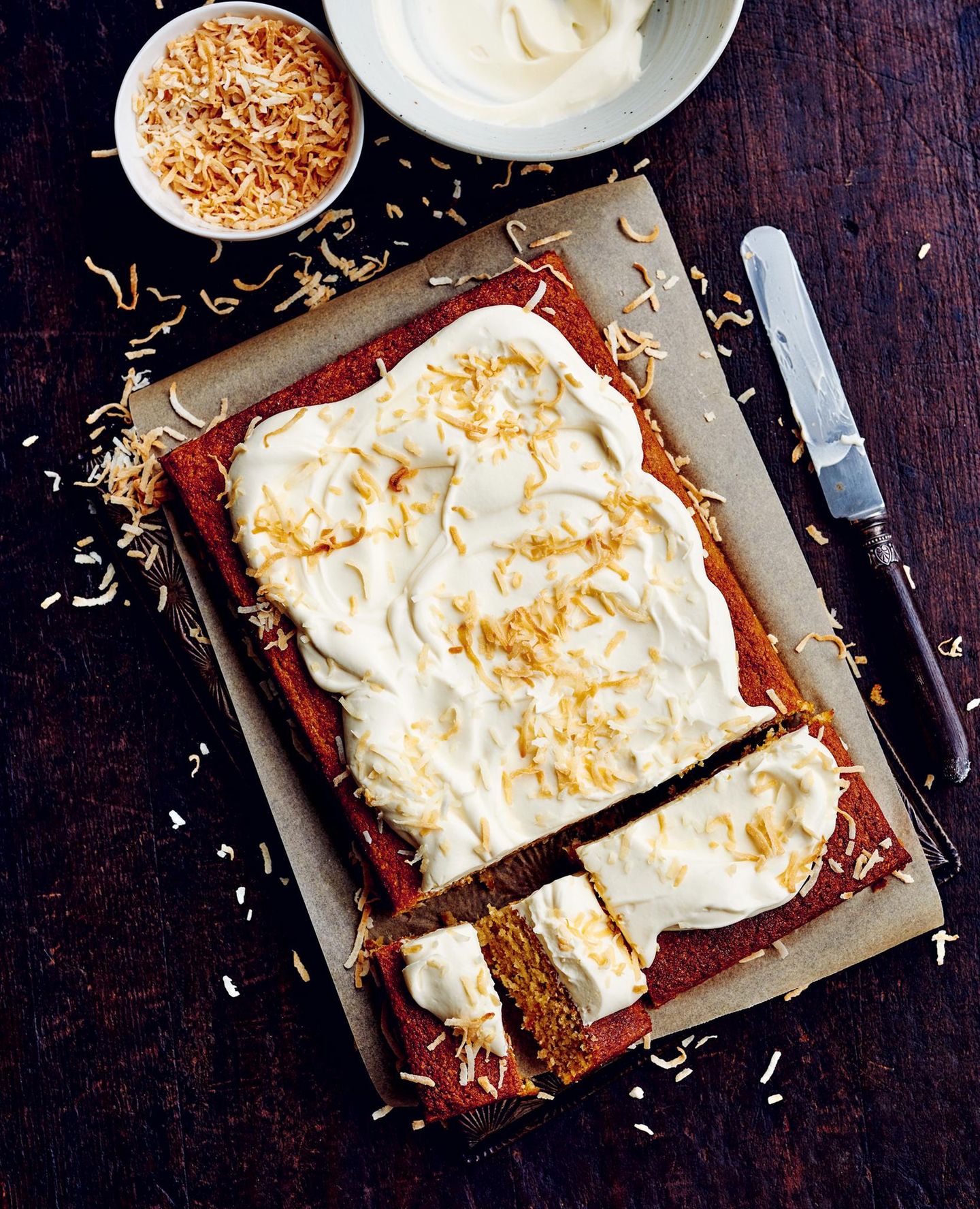 Bananen-Kokos-Traumkuchen     2 Eier  390 g zerdrückte Bananen  180 ml schwach aromatisches Olivenöl extra vergine  250 g griechischer Joghurt  240 g brauner Zucker  160 g Kokosflocken  120 g gemahlene Mandeln  80 g Reismehl  3 TL Backpulver    Joghurtglasur und geröstete Kokoschips zum Servieren  Den Backofen auf 160 °C vorheizen. Eine Kastenform (20 × 30 cm) mit Backpapier auslegen.  Eier, Banane, Öl, Joghurt und Zucker in einer Schüssel gründlich verschlagen. Kokosflocken, gemahlene Mandeln, Reismehl und Backpulver hineingeben und verrühren.  Den Teig in die vorbereitete Form füllen und 45–50 Minuten backen, bis der Kuchen nach Stäbchenprobe gar ist. 10 Minuten in der Form abkühlen lassen, dann auf einen Kuchenrost stürzen und vollständig erkalten lassen.  Auf einer Kuchenplatte anrichten. Mit der Joghurtglasur bestreichen und mit gerösteten Kokoschips bestreuen, dann servieren.     Rezept für Joghurtglasur: 250 g Mascarpone, 250 g griechischen Joghurt, 1 Esslöffel Honig und 1 Teelöffel Vanilleextrakt in einer Schüssel luftig aufschlagen.   