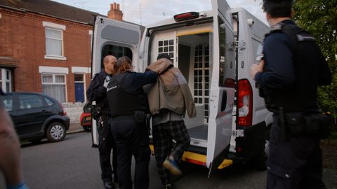 Zwei Beamte der britischen Einwanderungsbehörde verhaften einen Migranten. Ihnen droht in England die Abschiebung nach Ruanda