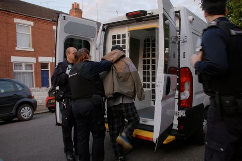 Zwei Beamte der britischen Einwanderungsbehörde verhaften einen Migranten. Ihnen droht in England die Abschiebung nach Ruanda
