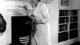 Agatha Christie in ihrem Haus vor dem Kamin im Wohnzimmer