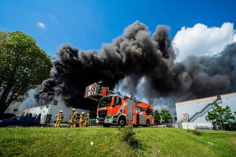 Schwarze Rauchwolken ziehen aus der brennenden Halle in Berlin-Lichterfelde ab