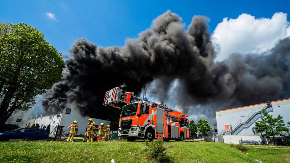 Schwarze Rauchwolken ziehen aus der brennenden Halle in Berlin-Lichterfelde ab