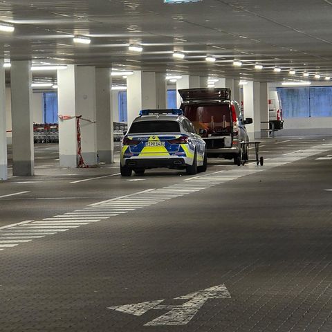In Regensburg stehen in einer Tiefgarage ein Polizeiauto und ein Transporter der Spurensicherung