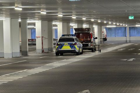 In Regensburg stehen in einer Tiefgarage ein Polizeiauto und ein Transporter der Spurensicherung