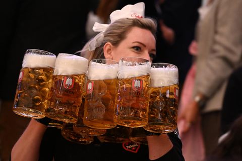 Kellnerin auf dem Oktoberfest trägt Bierkrüge. In der Gastronomie wird oft nur Mindestlohn gezahlt.
