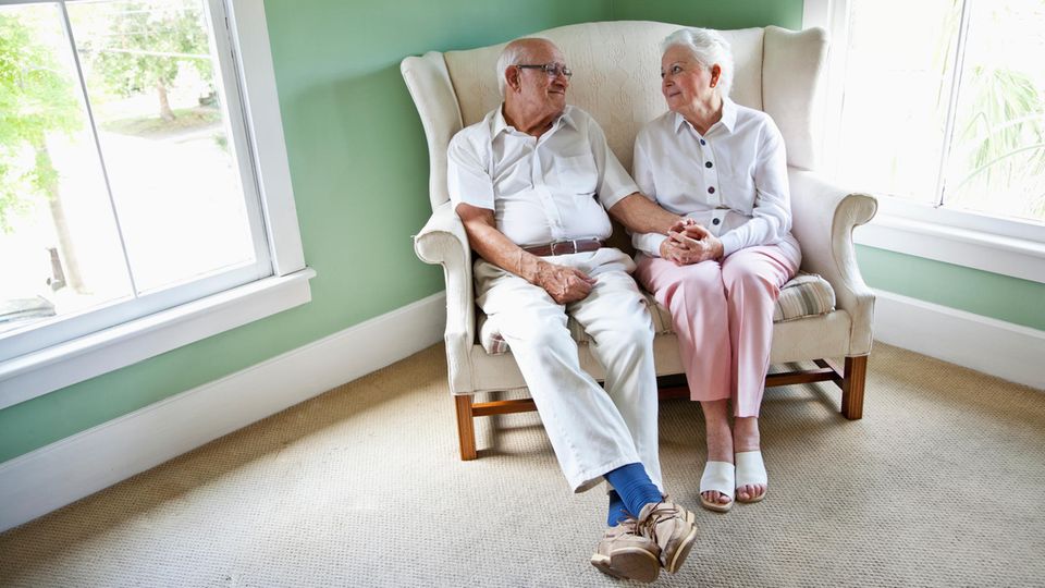 Pflege: Ein Seniorenpaar sitzt auf dem Sofa