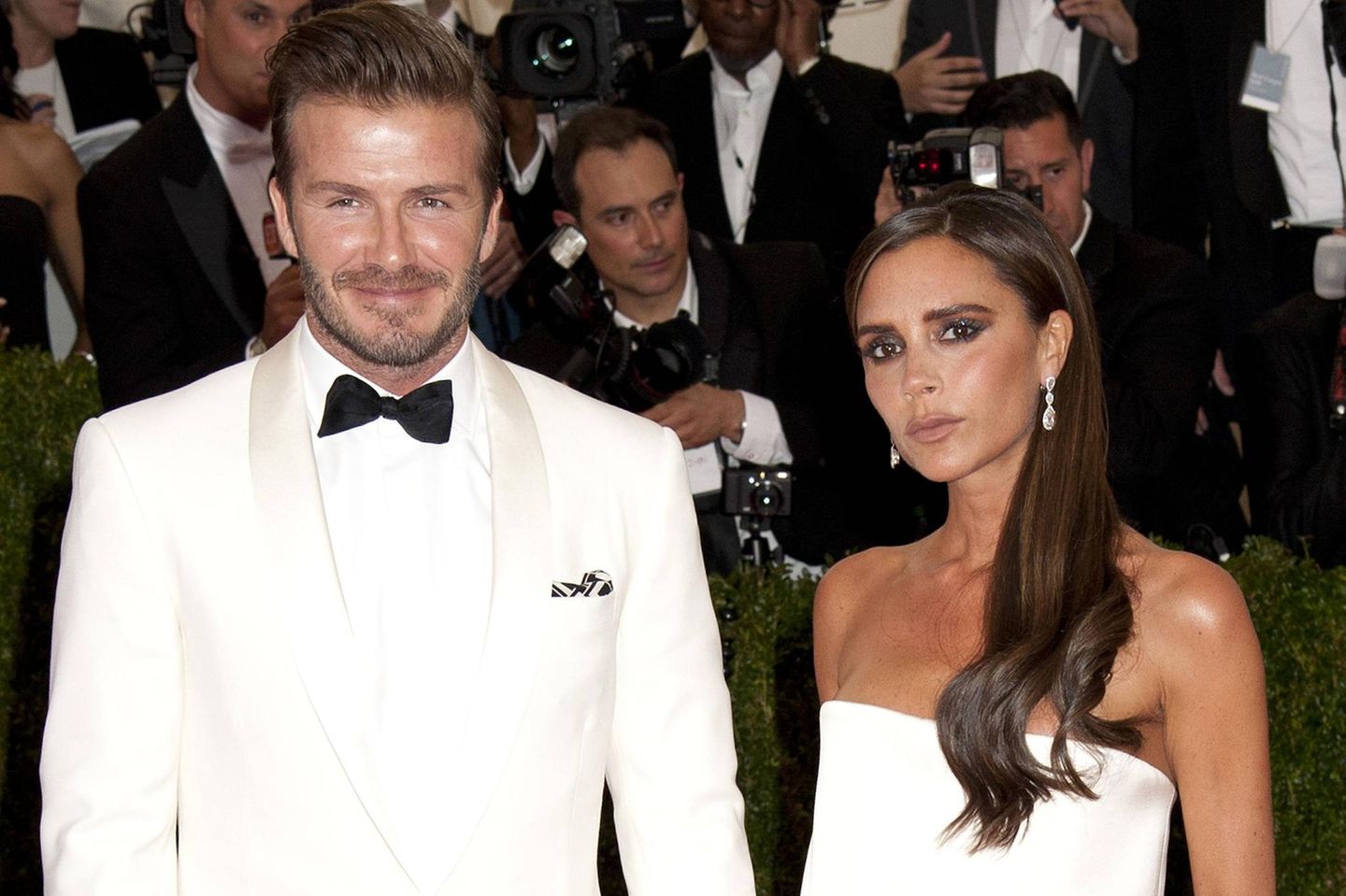 David und Victoria Beckham mit Fotografen im Hintergrund