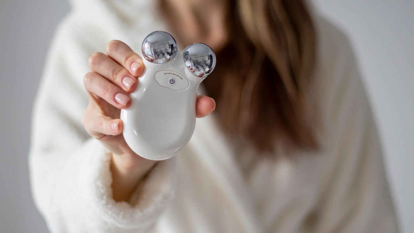 Person hält ein Gesichtsmassagegerät