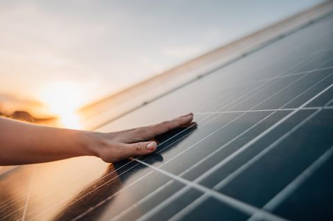 Größe beim Balkonkraftwerks - spielt sie eine Rolle? Hand auf Solarpanel.