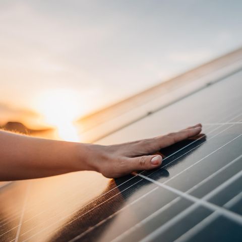 Größe beim Balkonkraftwerks - spielt sie eine Rolle? Hand auf Solarpanel.