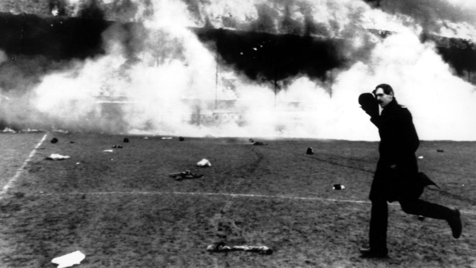 Ein Polizist bringt sich vor den Flammen und der unerträglichen Hitze in Sicherheit