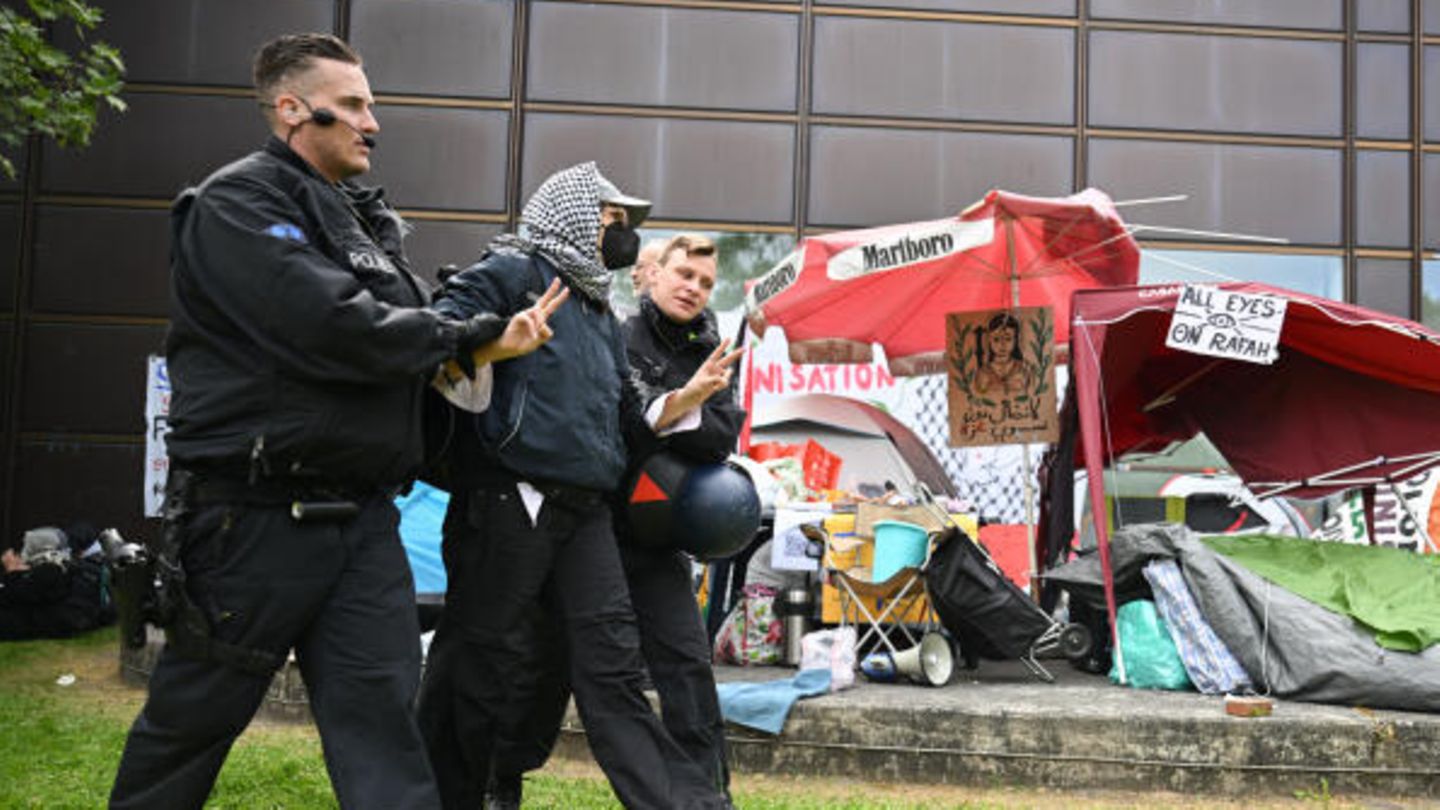 Ein Demonstrant der Gruppe "Student Coalition Berlin" wird auf dem Theaterhof der FU Berlin abgeführt