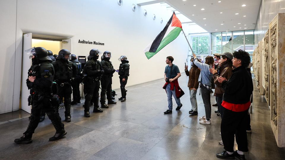 Aktivisten und Studenten schwenken die palästinensische Flagge, als die Polizei an der Uni Leipzig durchgreift