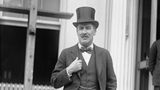 Howard Carter in Frack mit Zylinderhut steht vor dem Weißen Haus