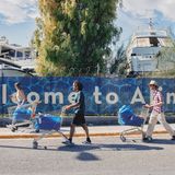 Die Reisenden laufen vor dem Hafengelände mit Einkaufswagen über die Straße.
