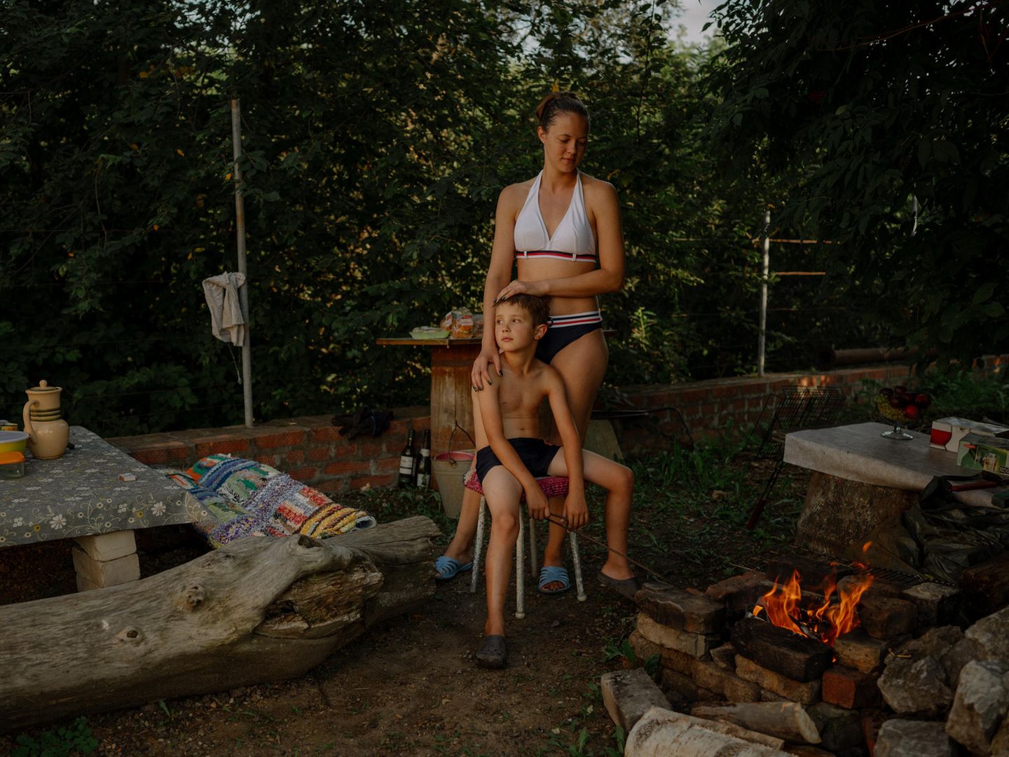 Meine Schwester umarmt ihren neunjährigen Sohn in einerm Garten.