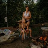 Meine Schwester umarmt ihren neunjährigen Sohn in einerm Garten.