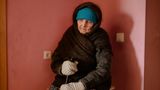 Oma sitzt in einer Ecke des Raumes und wartet auf den Beginn des Spaziergangs.