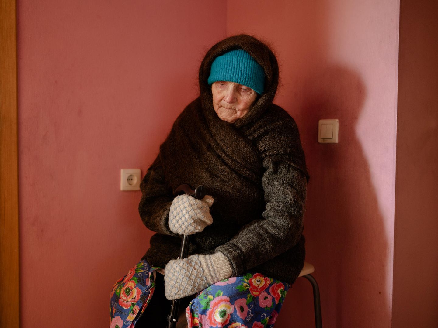 Oma sitzt in einer Ecke des Raumes und wartet auf den Beginn des Spaziergangs.
