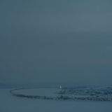 Eine Landschaft im Schnee. Es dringt kaum Licht durch die Wolken.