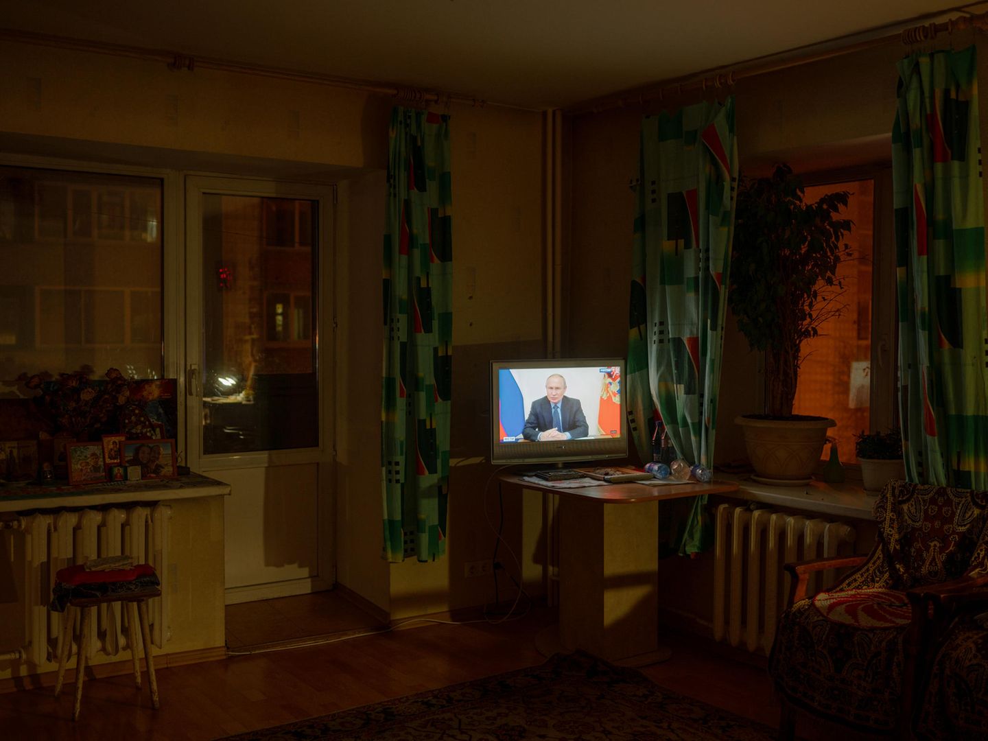Ein laufender Fernseher in einem dunklen Wohnzimmer.