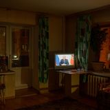 Ein laufender Fernseher in einem dunklen Wohnzimmer.